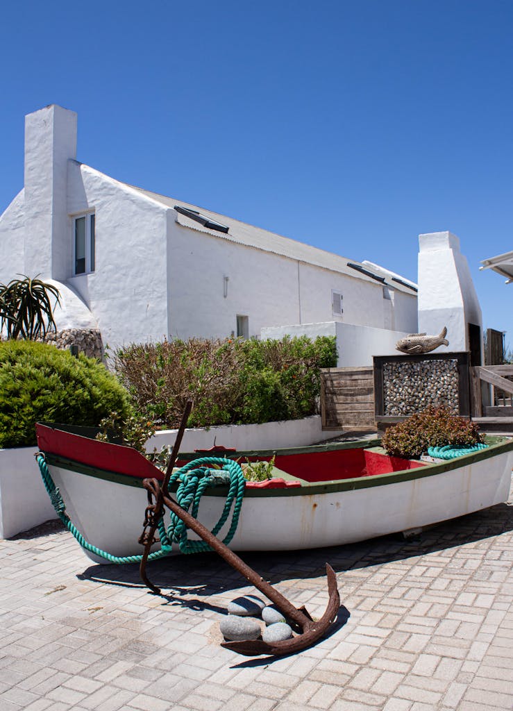A picturesque scene of a white house and boat under clear skies in Paternoster, South Africa.