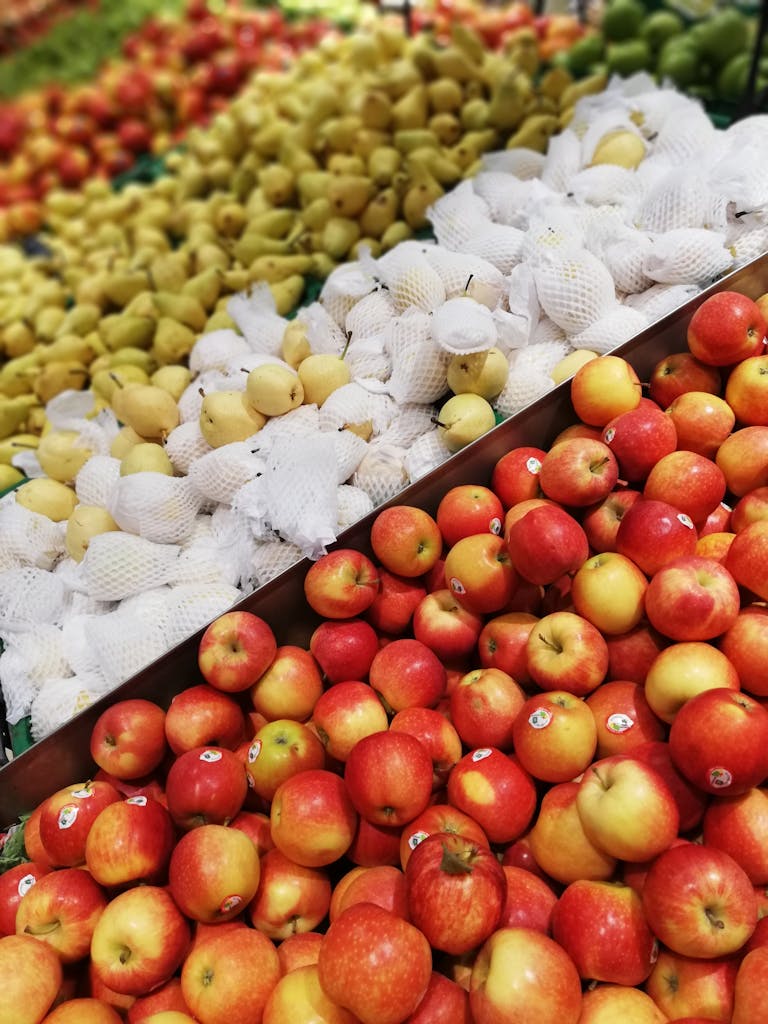 A vibrant display of fresh apples and pears at a local market stall, perfect for a healthy lifestyle.