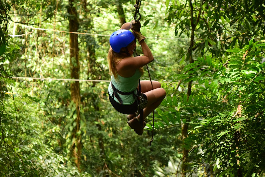 A woman ziplining through lush Costa Rican forests, showcasing adventure and nature.