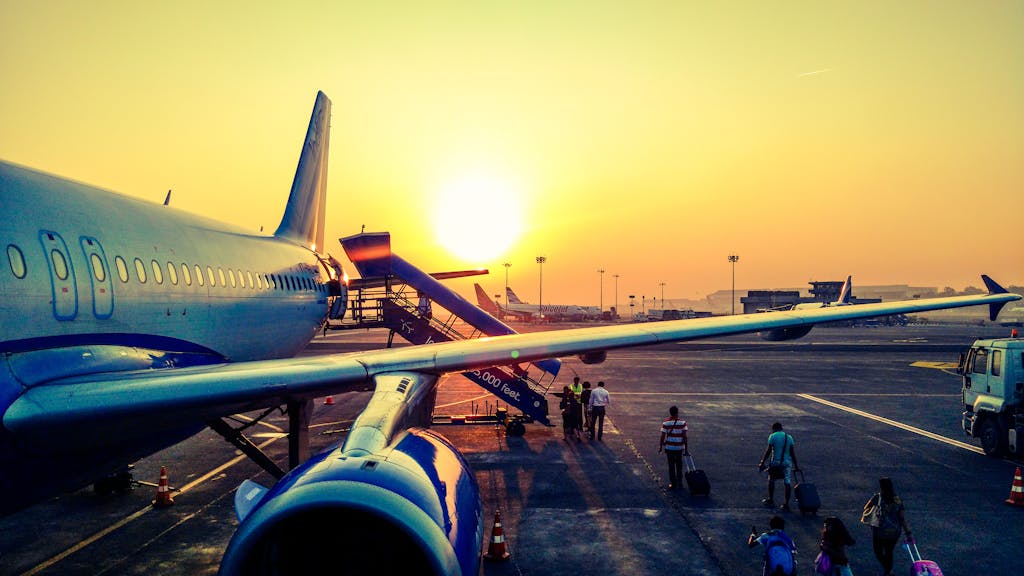 A vibrant image of passengers boarding an airplane at sunrise, highlighting air travel.