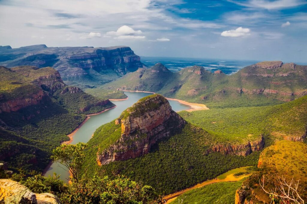 Explore the breathtaking vistas of Blyde River Canyon with dramatic cliffs and lush greenery.