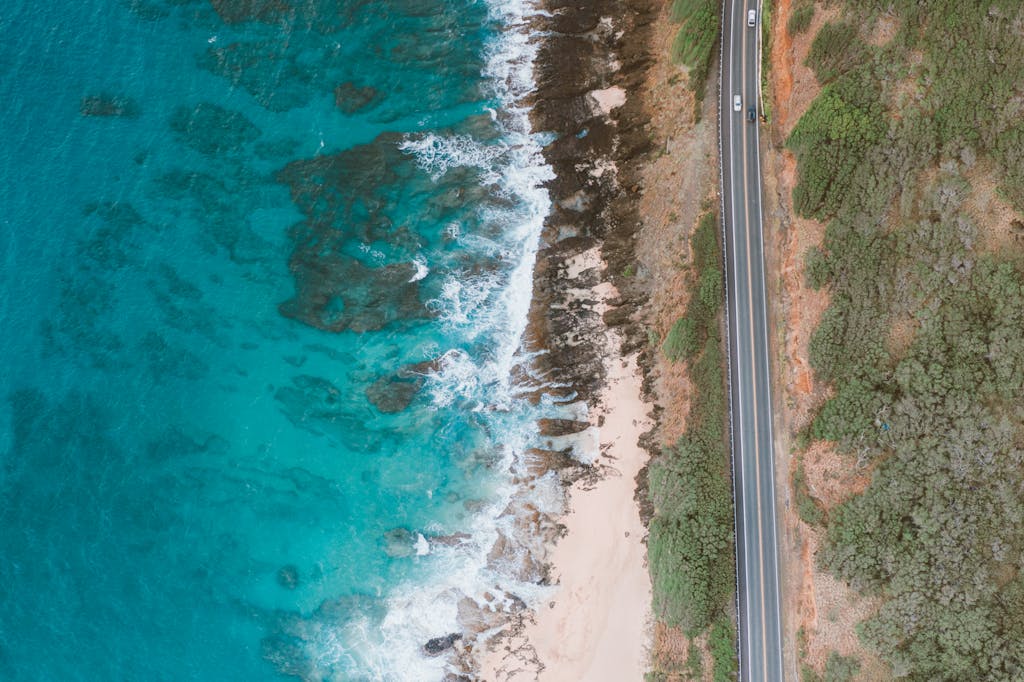 Aerial shot of Hawaii's stunning coastline with turquoise waters and rugged cliffs.