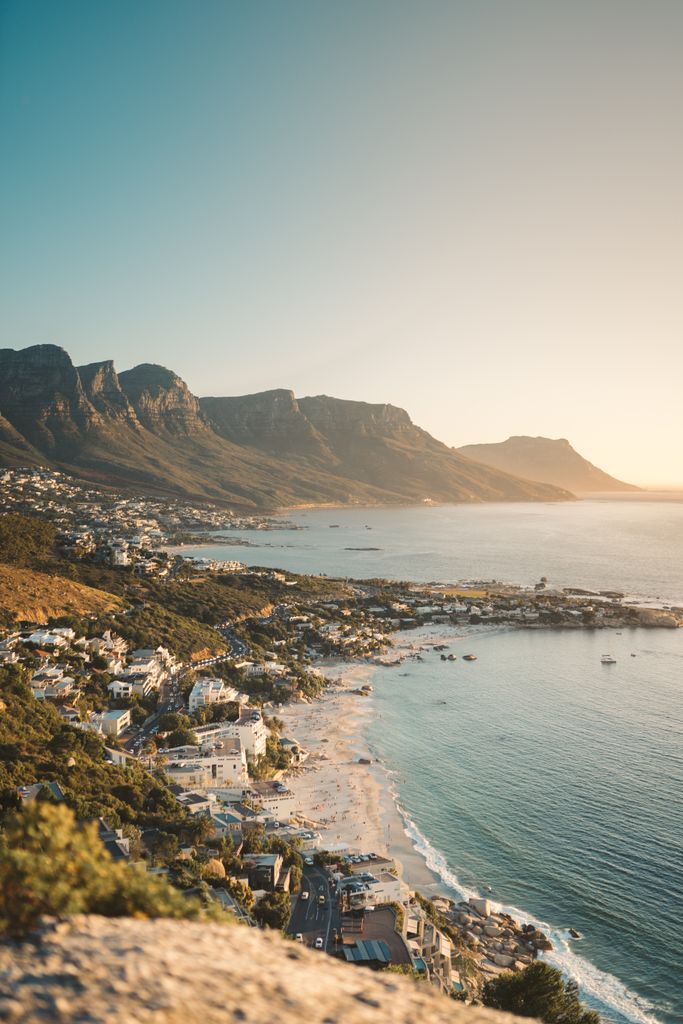 A breathtaking sunset view of Cape Town's coastal landscape with mountains and ocean.